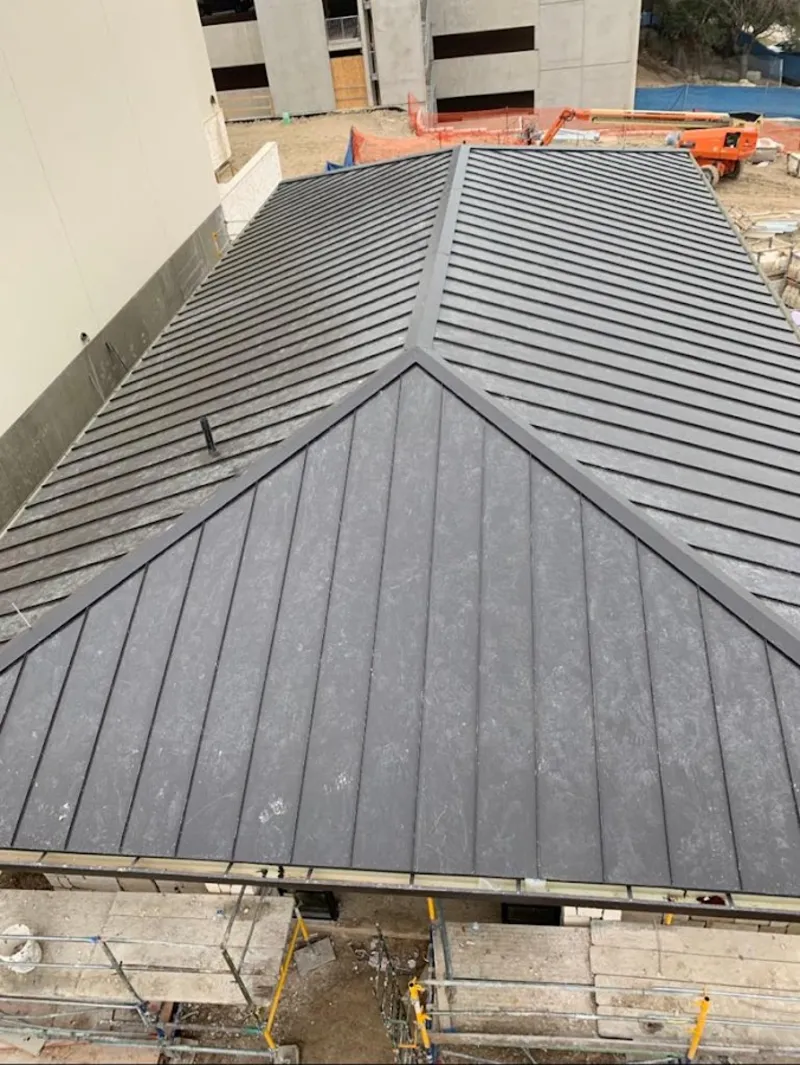 Commercial metal roof construction with crane equipment in Harrison